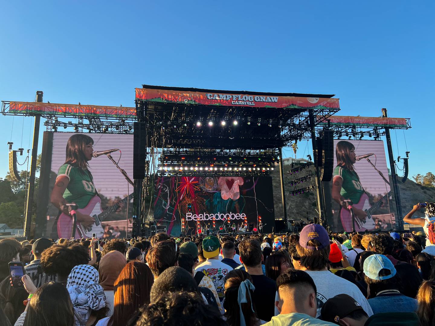 Photo of a stage with three screens overlooking a crowd