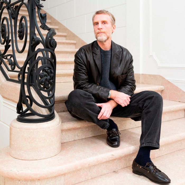 A man in black sits of stairs