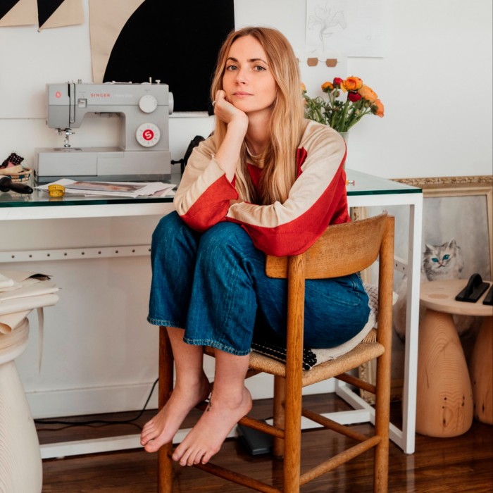 Sam Klemick sitting in a chair in her studio