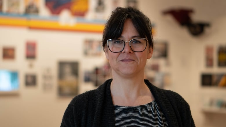 A woman poses for a photo in an art gallery.