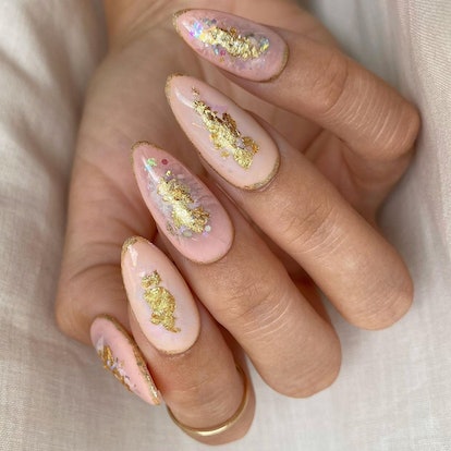 A peach fuzz manicure with gold leaf detailing is on-trend for a 2024 