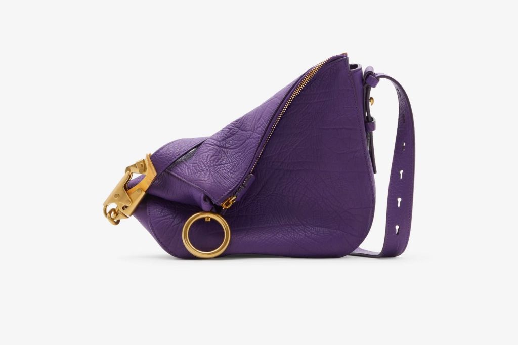 Purple slouchy purse with gold colored hardware. 