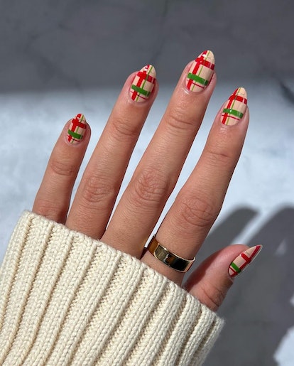 For a classy Christmas nail design for the 2023 holiday season, red and green plaid nails are festiv...