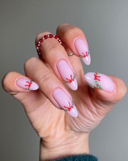 For a simple Christmas nail design for the 2023 holiday season, try a festive garland and ribbon Fre...