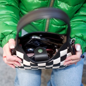 Woman holding black and white shoulder bag 