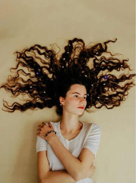 A girl with brown curly hair lying down