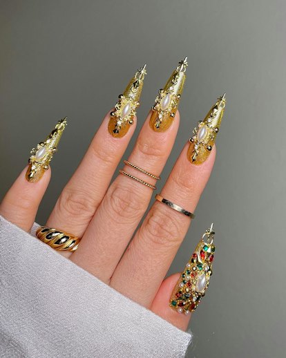 Decadent gold chrome nails with gilded gems and pearls match the mob wife aesthetic.