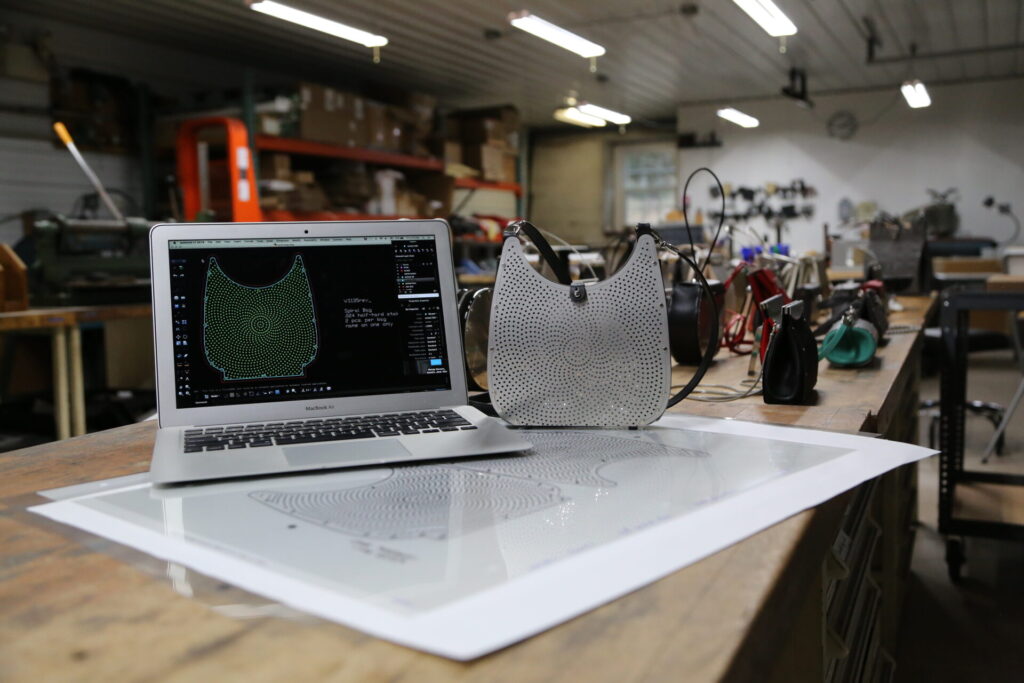 Mac laptop in workshop with metal handbag