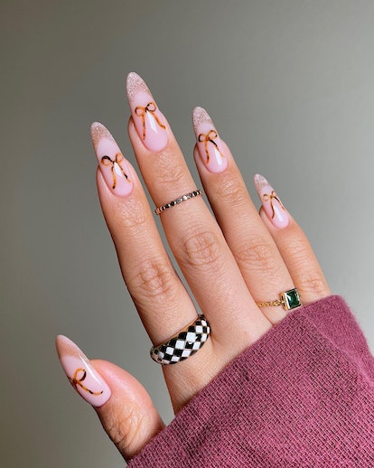 Coquette ribbon nail art is on-trend for 2024.