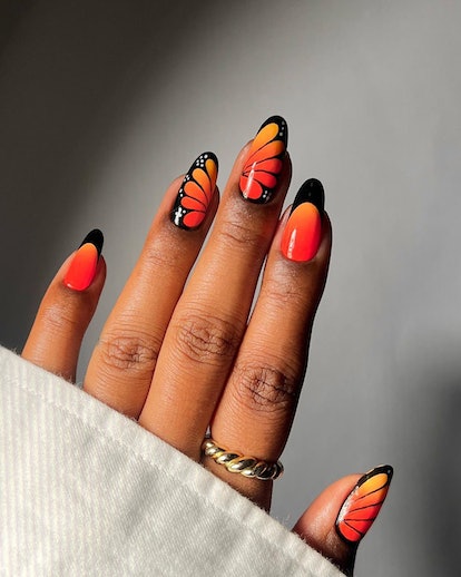 Orange monarch butterfly nail art is on-trend for 2024's Aquarius season.