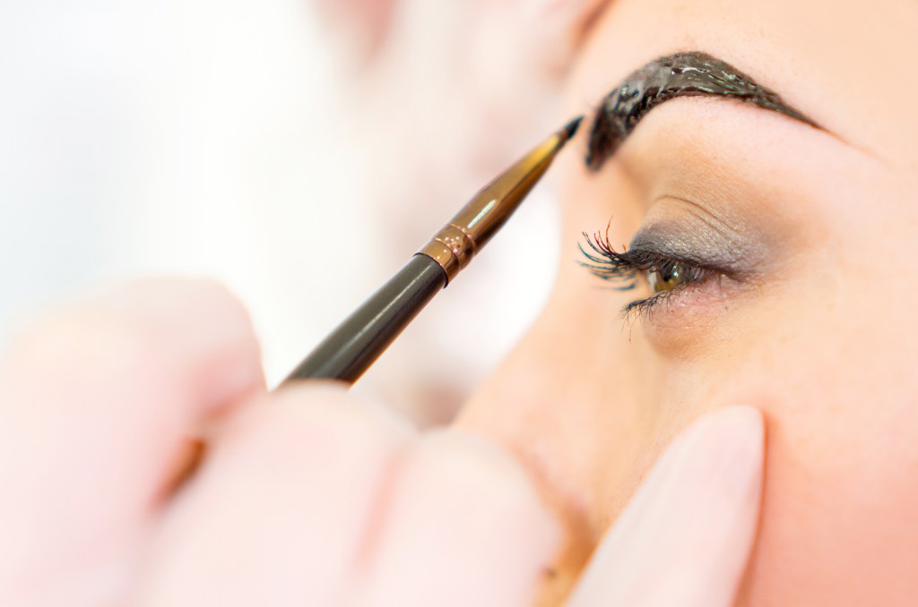 woman dyeing eyebrows at home