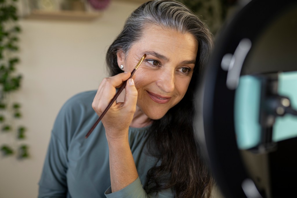 mature woman filling in eyebrows