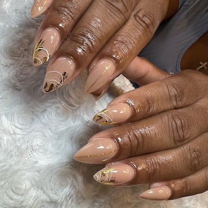 Manicures with gold flake details are on-trend for the 2024 Super Bowl.