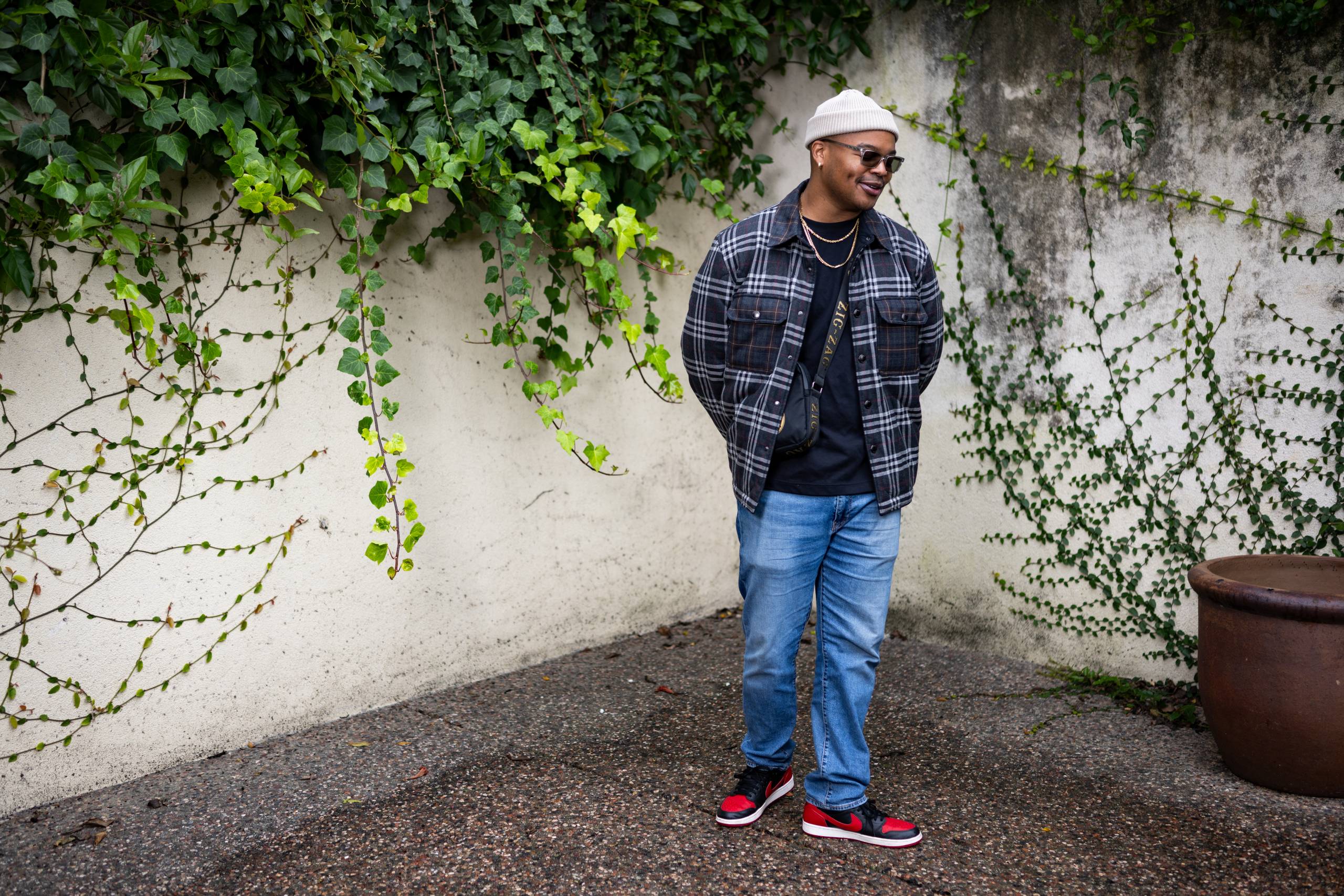 Person in plaid jacket, jeans, beanie and sunglasses