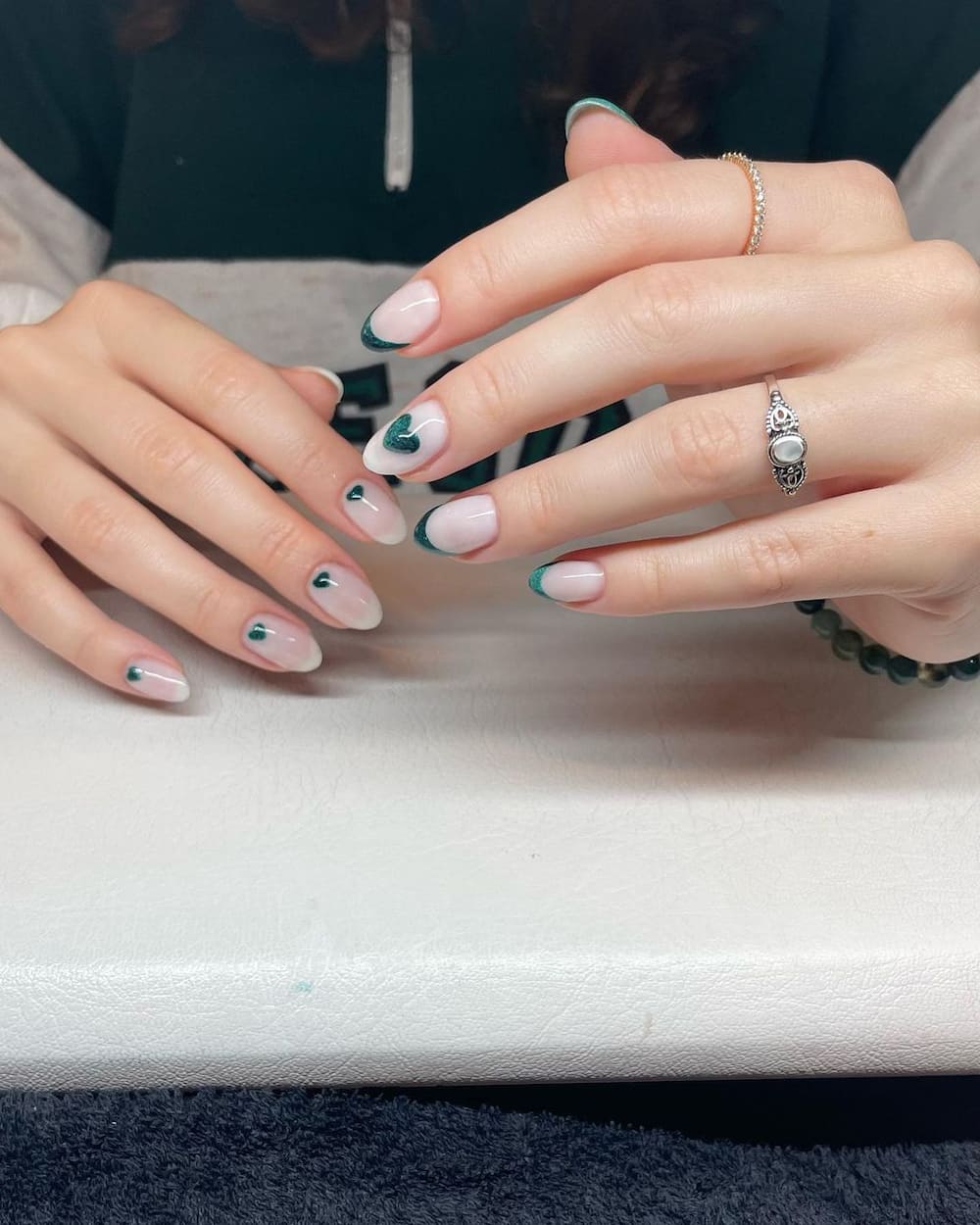 Glitter St. Patrick's Day hearts nail design.