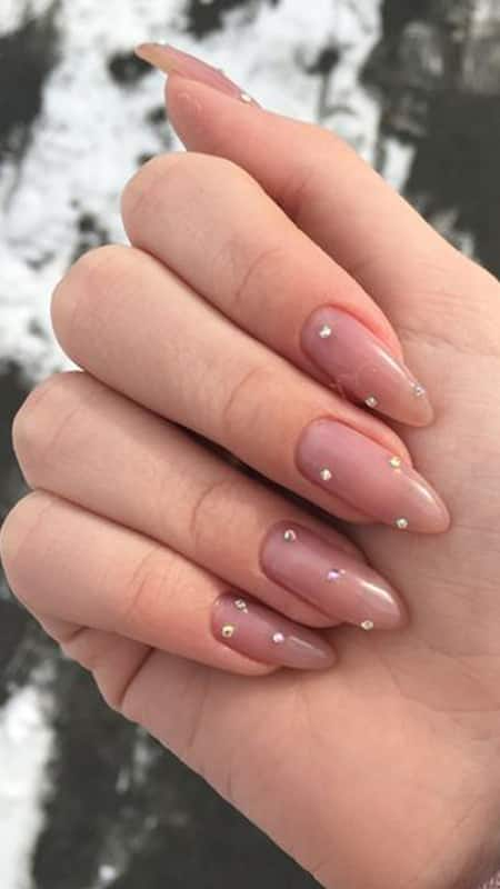 Rhinestone Nails: Almond-shaped nails featuring a sheer pink base with delicate rhinestones, offering a playful yet sophisticated look.