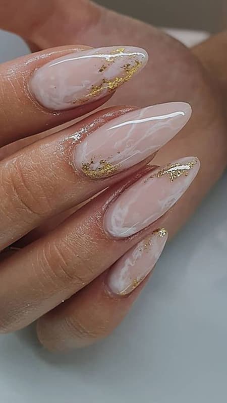 Golden Marble Glam: This design showcases a luxurious marbled effect with gold foil, blending opulence and artistry on long, sculpted nails.