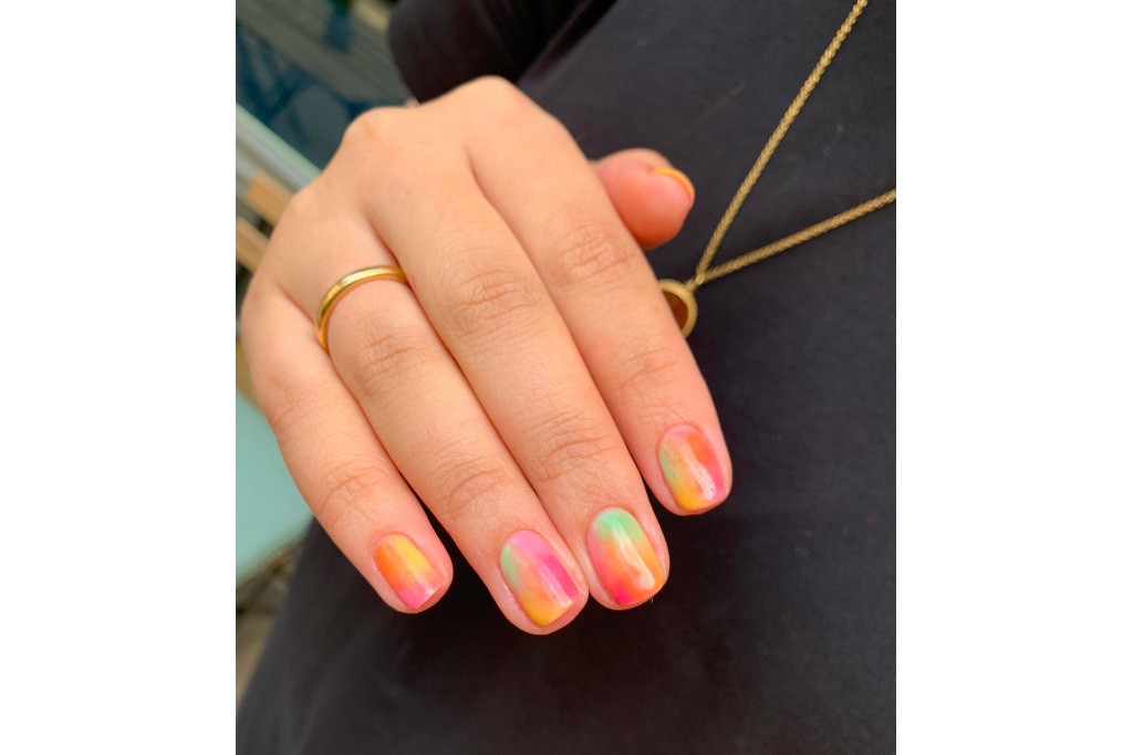 Close up of hand with multicoloured nails