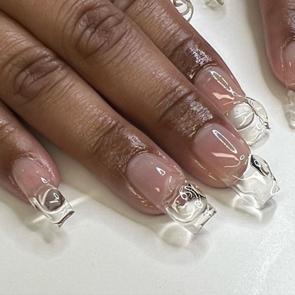 Clear nails with 3D designs match the 