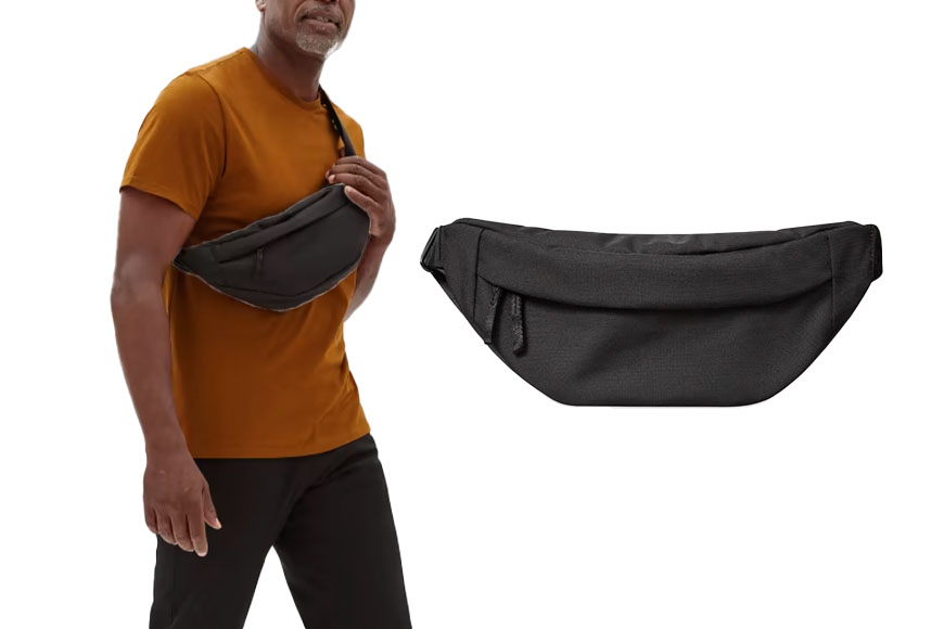 A man holding a black pack while wearing an orange shirt and black pants - everlane