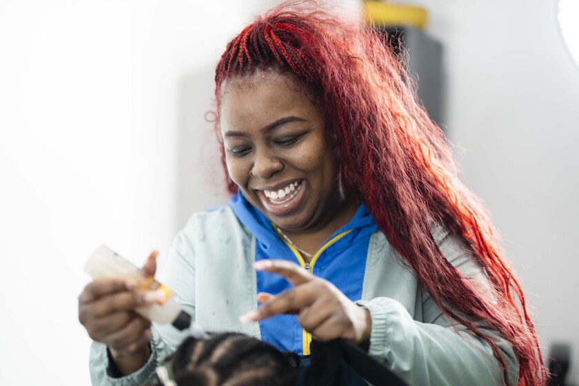 Jasmine Valentine, whose hair styling business is called Crowned by Jai, prepares a client’s hair for a weave at The Exotic Haus Salon Suites in the Roseland neighborhood late last year. Pat Nabong / Sun-Times