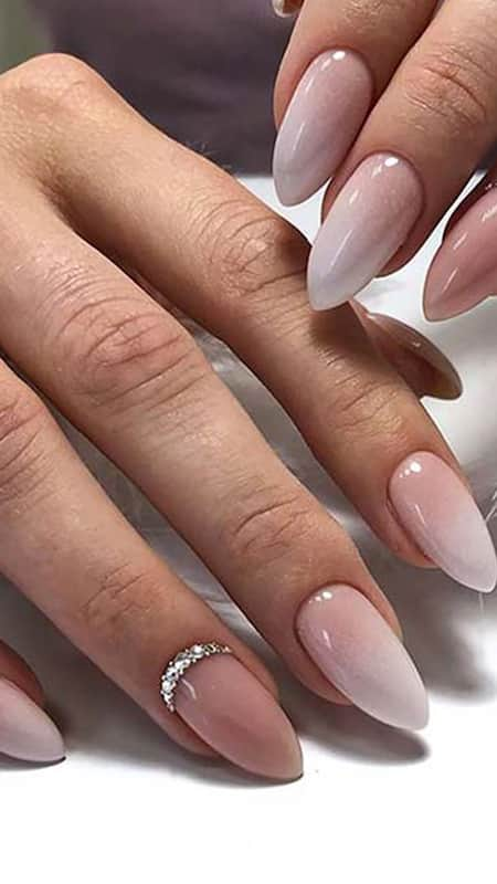 Long almond-shape, diamond nails with a glossy nude-pink ombre finish.