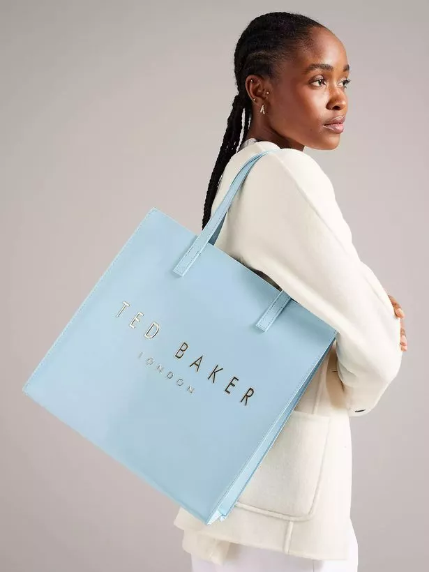 Person with a light blue Ted Baker tote bag