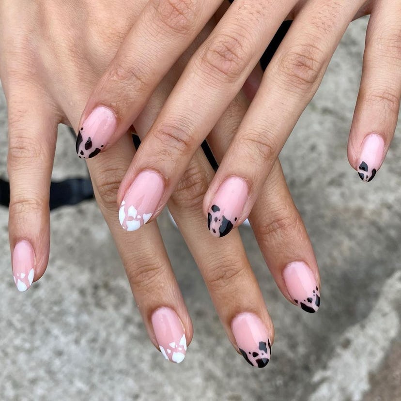 Try almond-shaped cow print French tip nails.