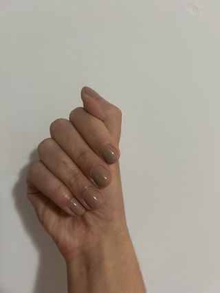 Gabrielle Ulubay's hand with light brown nail polish on