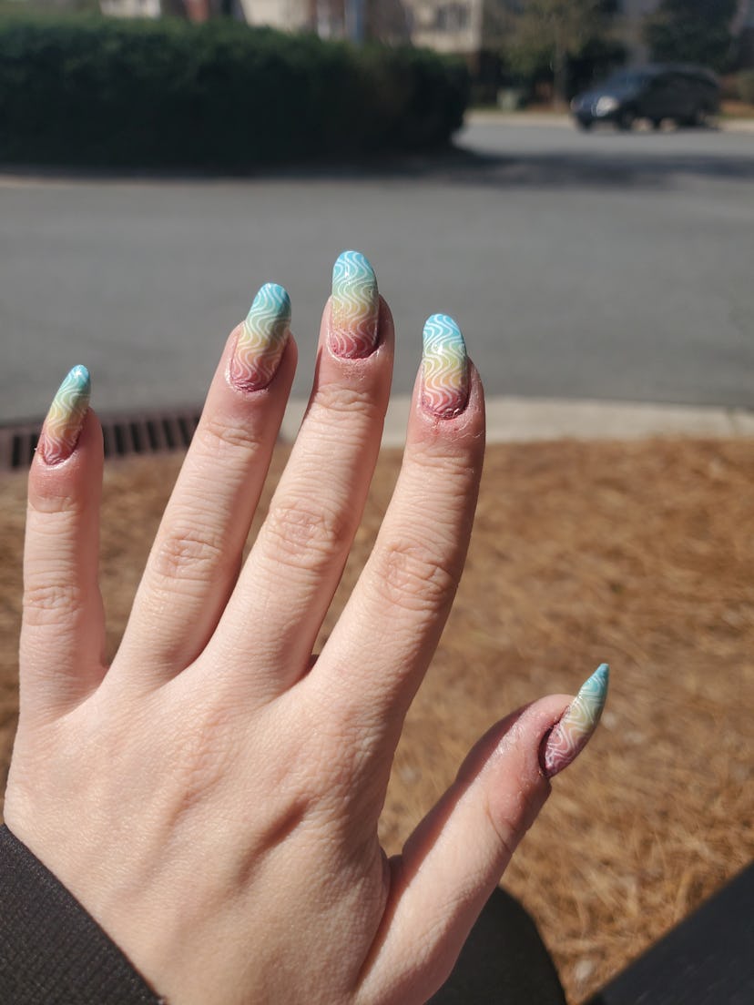 Subtle pride rainbow nail art design in the sun.