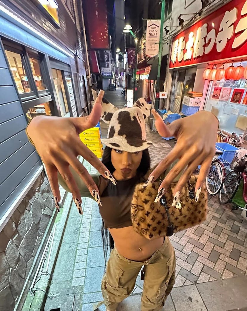 Megan Thee Stallion rocked black cow print nails while in Japan.