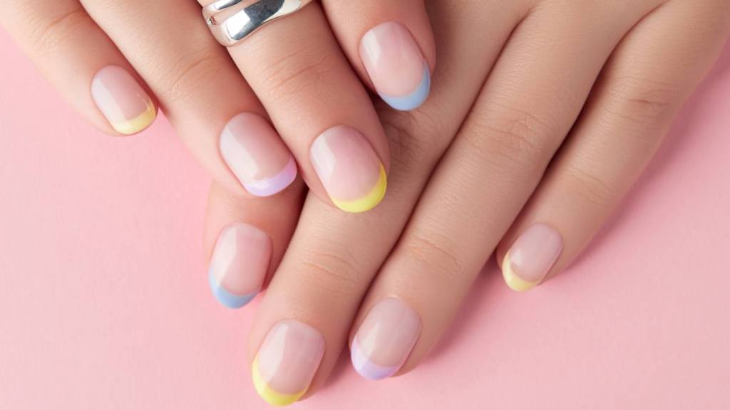 Close up manicured womans hands on pink background. Manicure, pedicure spring summer design trends (summer nail designs)