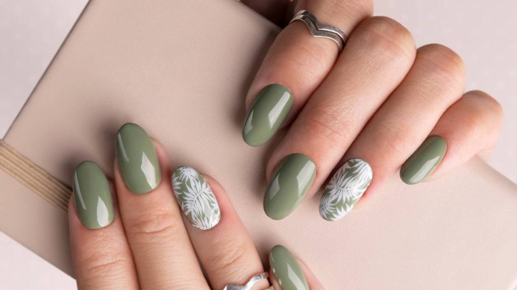 Beautiful womans hands with spring summer floral nail design. Trendy green color manicure close-up