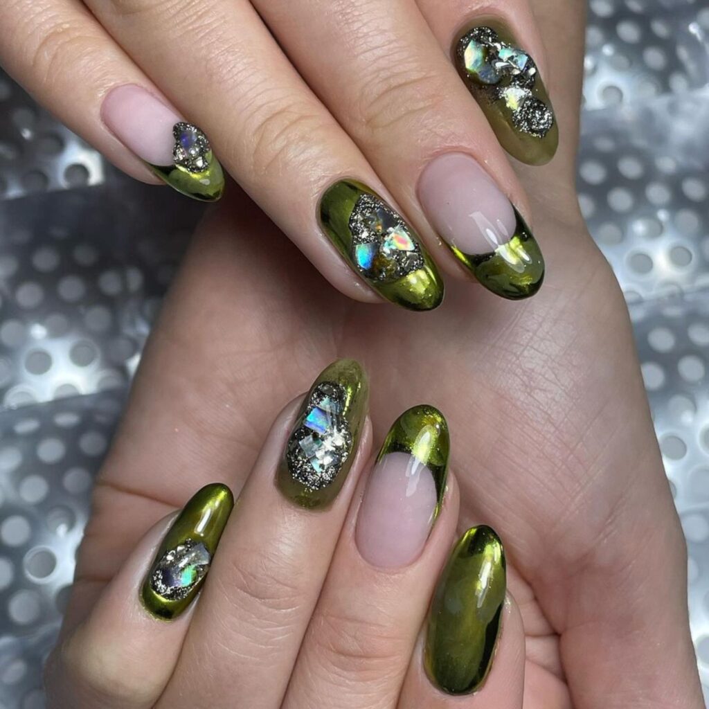 Victoria Houllis of Mannequin Hands says clients have been favouring jewel tone nails like these metallic gold emerald tipped nails with jewel inlays.