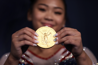 suni lee holding a gold medal at the 2020 games in tokyo