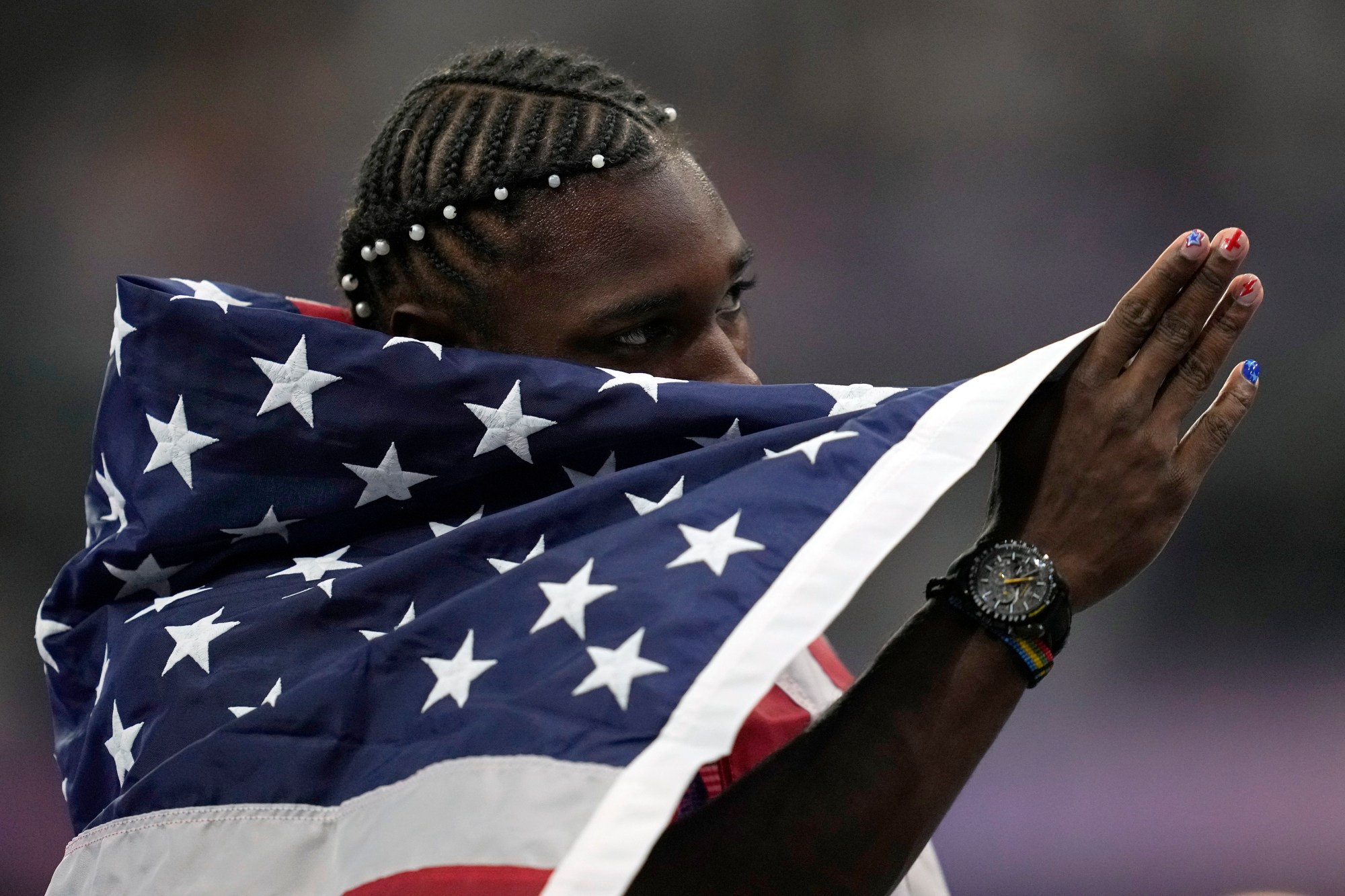 Noah Lyles, of the United States, celebrates after winning the gold medal in in the men's 100 meters final at the 2024 Summer Olympics, Sunday, Aug. 4, 2024, in Saint-Denis, France. (AP Photo/Ashley Landis)