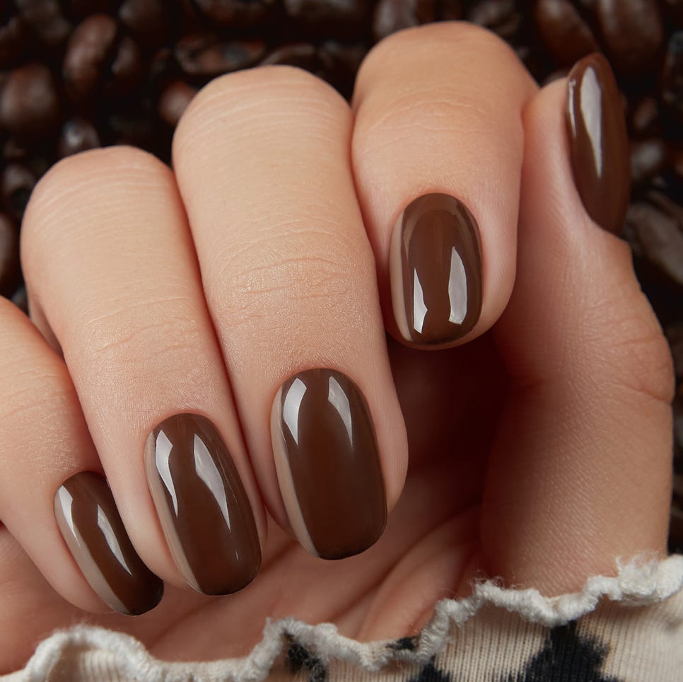 beautiful groomed womans hand with brown nail design manicure, pedicure beauty salon concept