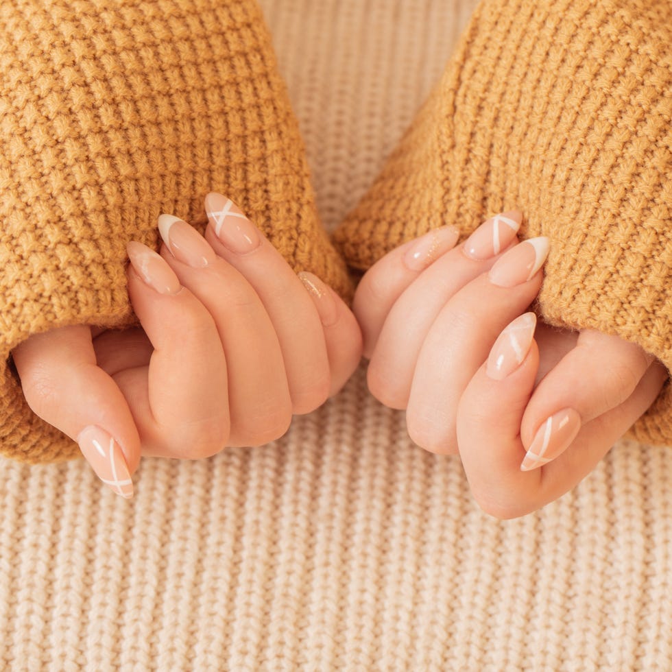 womans hands with manicure with knitted blanket