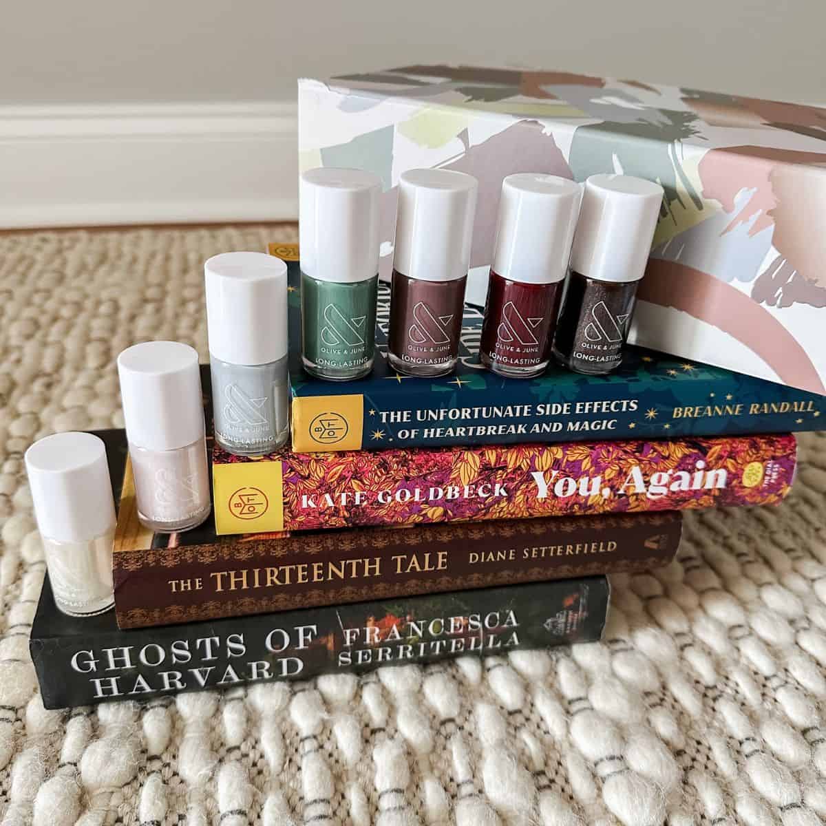 stack of books with olive and june's fall nail polish collection.