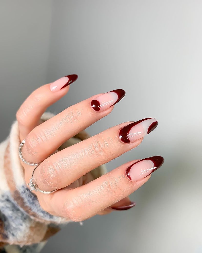 Nails with simple burgundy swirls are on-trend for fall 2024.