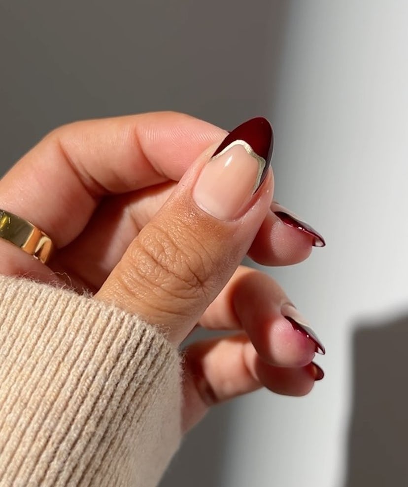 Burgundy French tips with avant-garde metallic accents are on-trend for fall 2024.