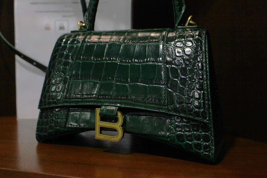 A green crocodile bag up close