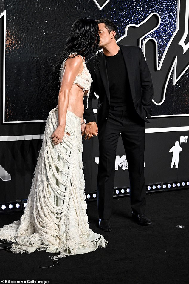 The couple sweetly held hands as they puckered up for a kiss on the red carpet