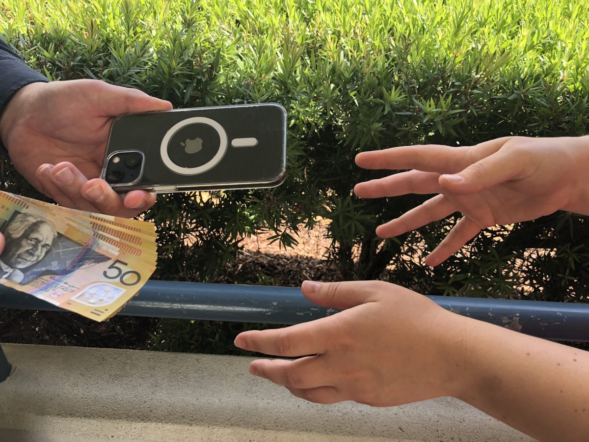 Person handing over a phone and money