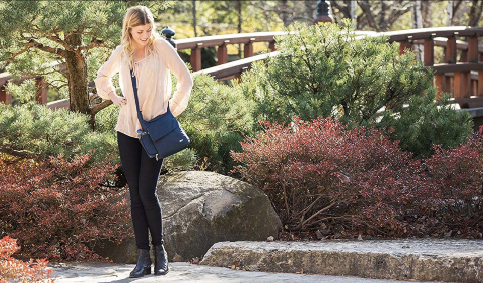 Woman with her anti-theft bag standing in a park.