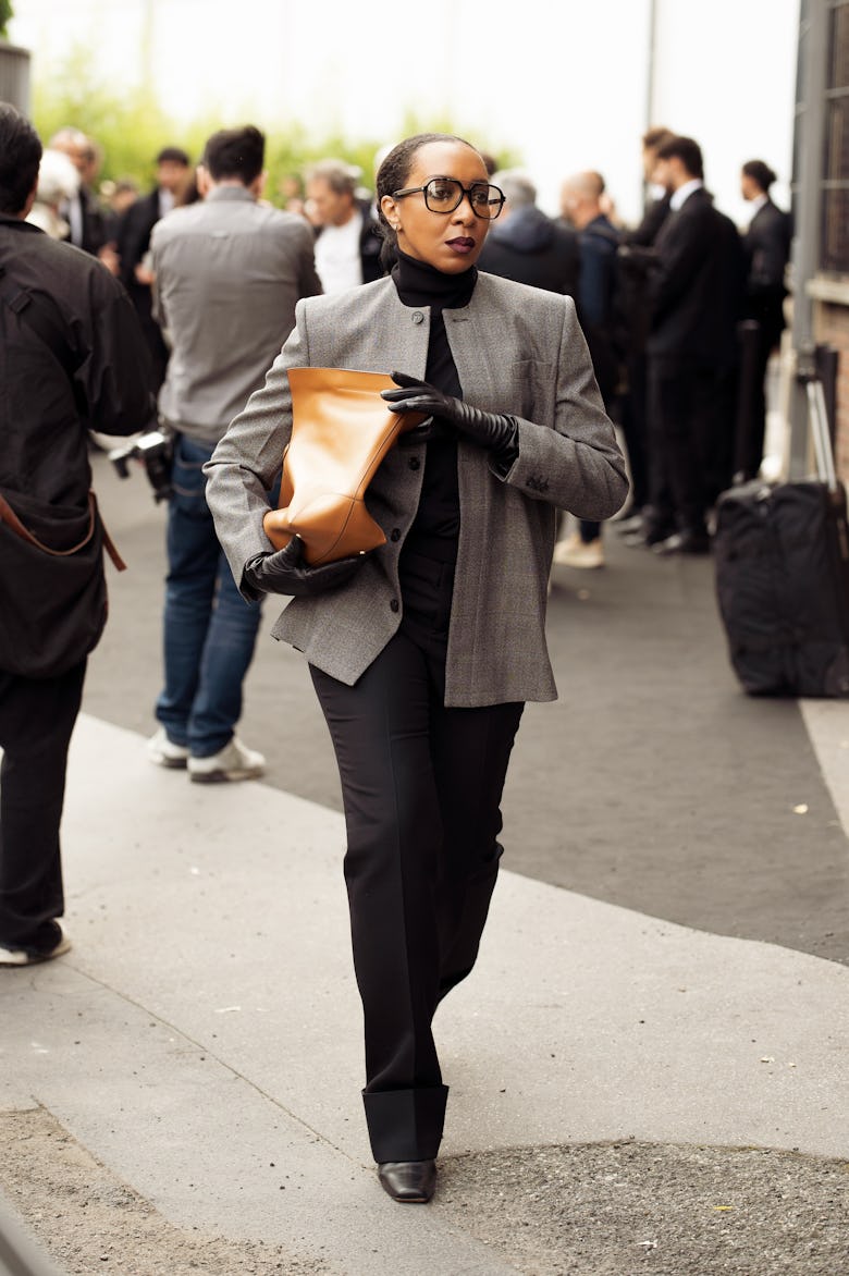 MILAN, ITALY - SEPTEMBER 20: Karen Blanchard wears black pants, black top, grey blazer and brown bag...