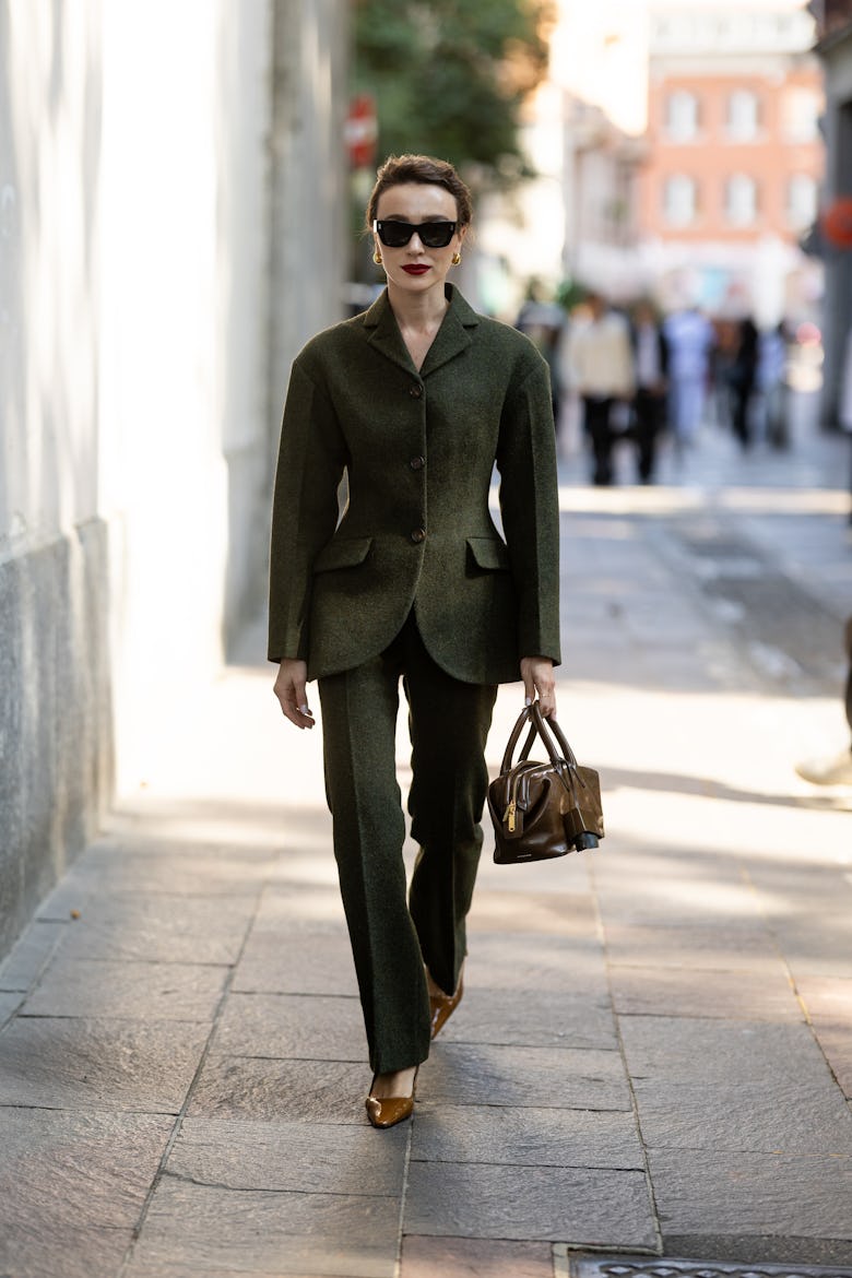 MILAN, ITALY - SEPTEMBER 21: Mary Leest wears black sunglasses, a brown leather bag, brown leather p...