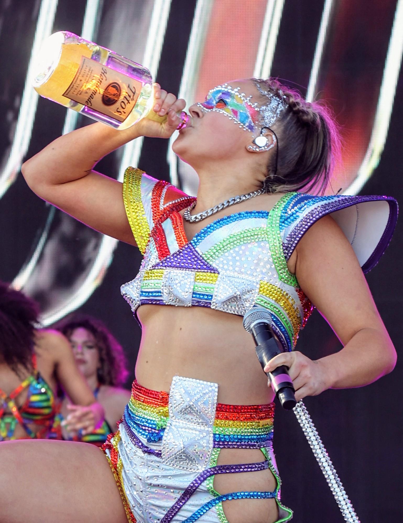 Jojo Siwa chugs from a Titos vodka bottle on stage