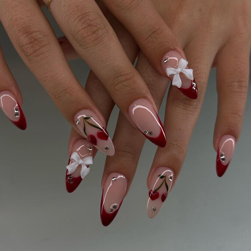 Burgundy cherry nail art and 3D ribbon adornments are perfect for Scorpio season 2024.