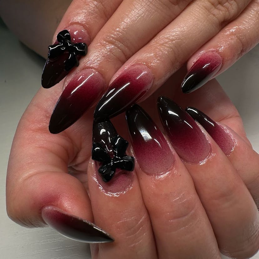 Blood red ombré nail art with 3D ribbon charms match the the dark coquette trend.